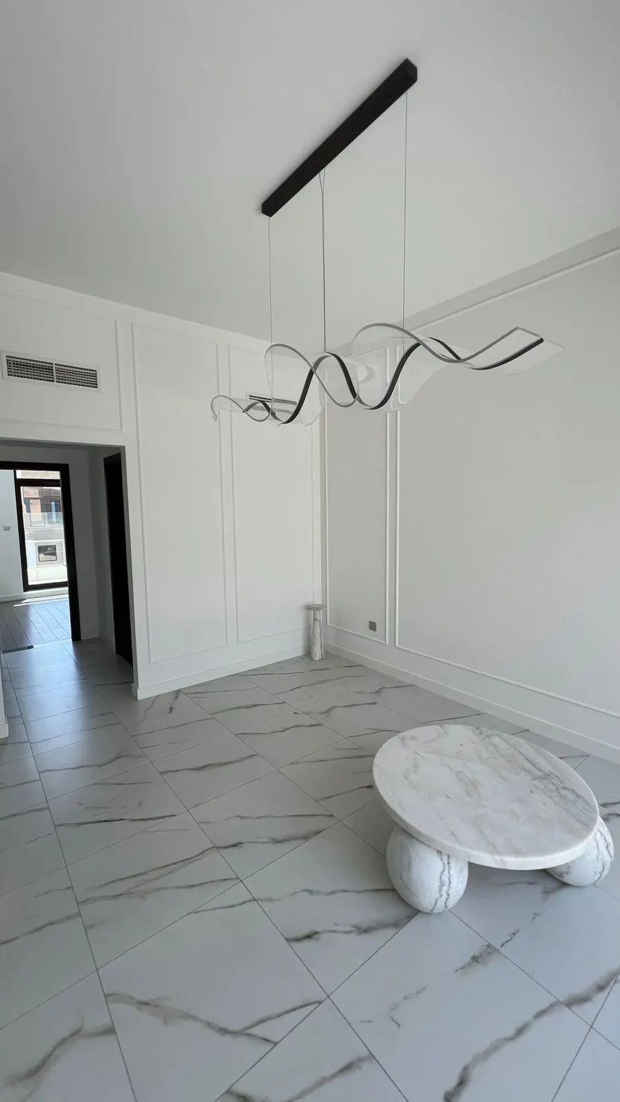 Living area with marble-look tiles and a sculptural pendant light, Wadi Al Safa 3
