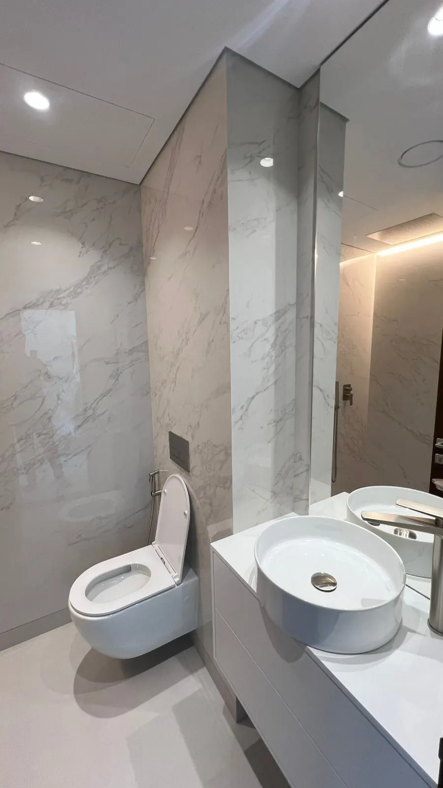 Bathroom with marble-look walls and a wall-hung toilet, Wadi Al Safa 3